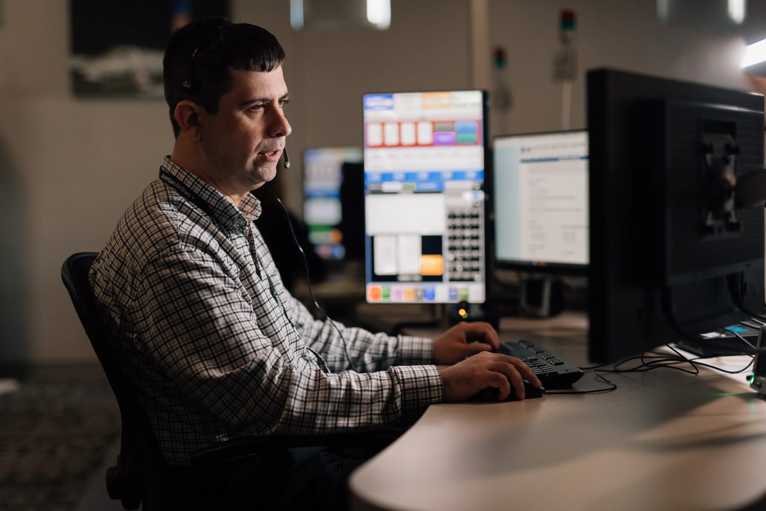 Man smiling while staring and typing at a computer